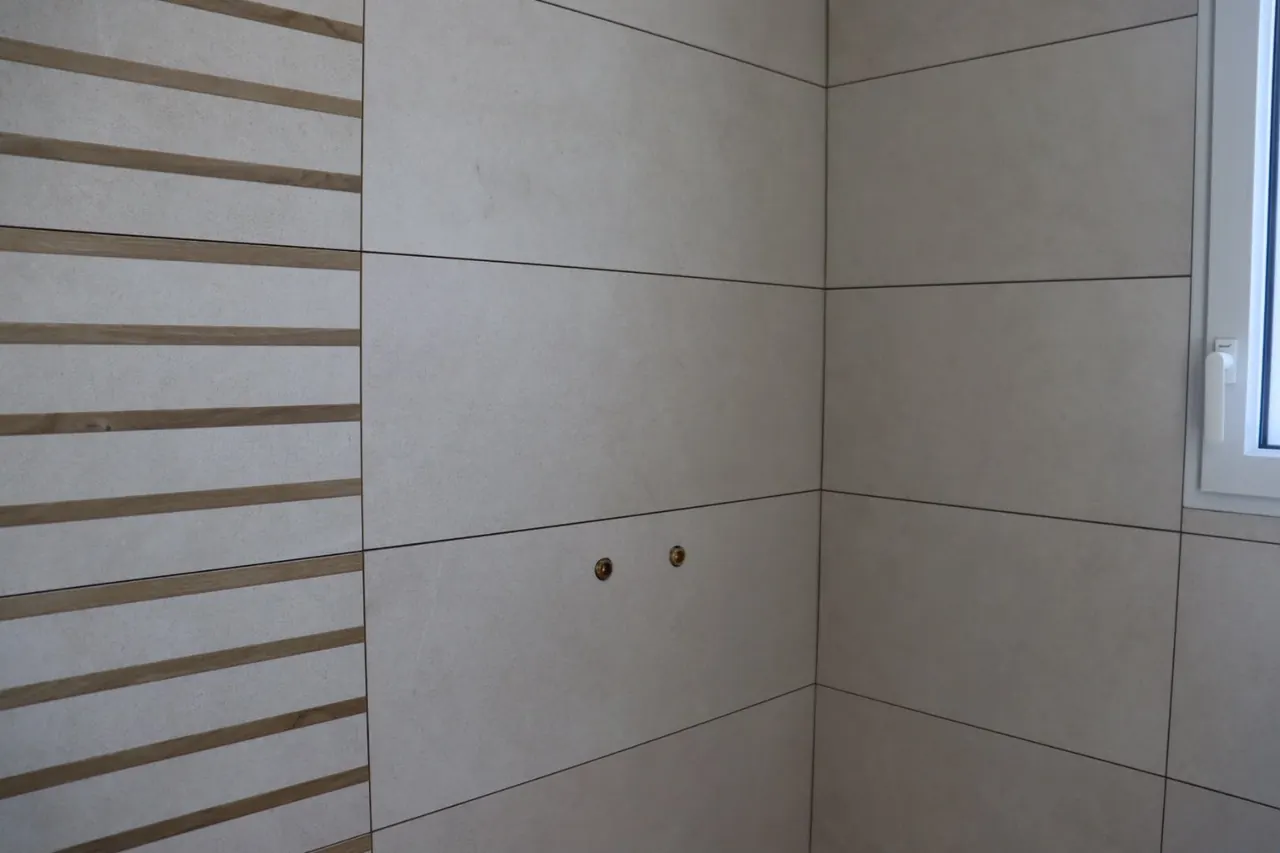Salle de bain en grand format gris clair et listels effet bois