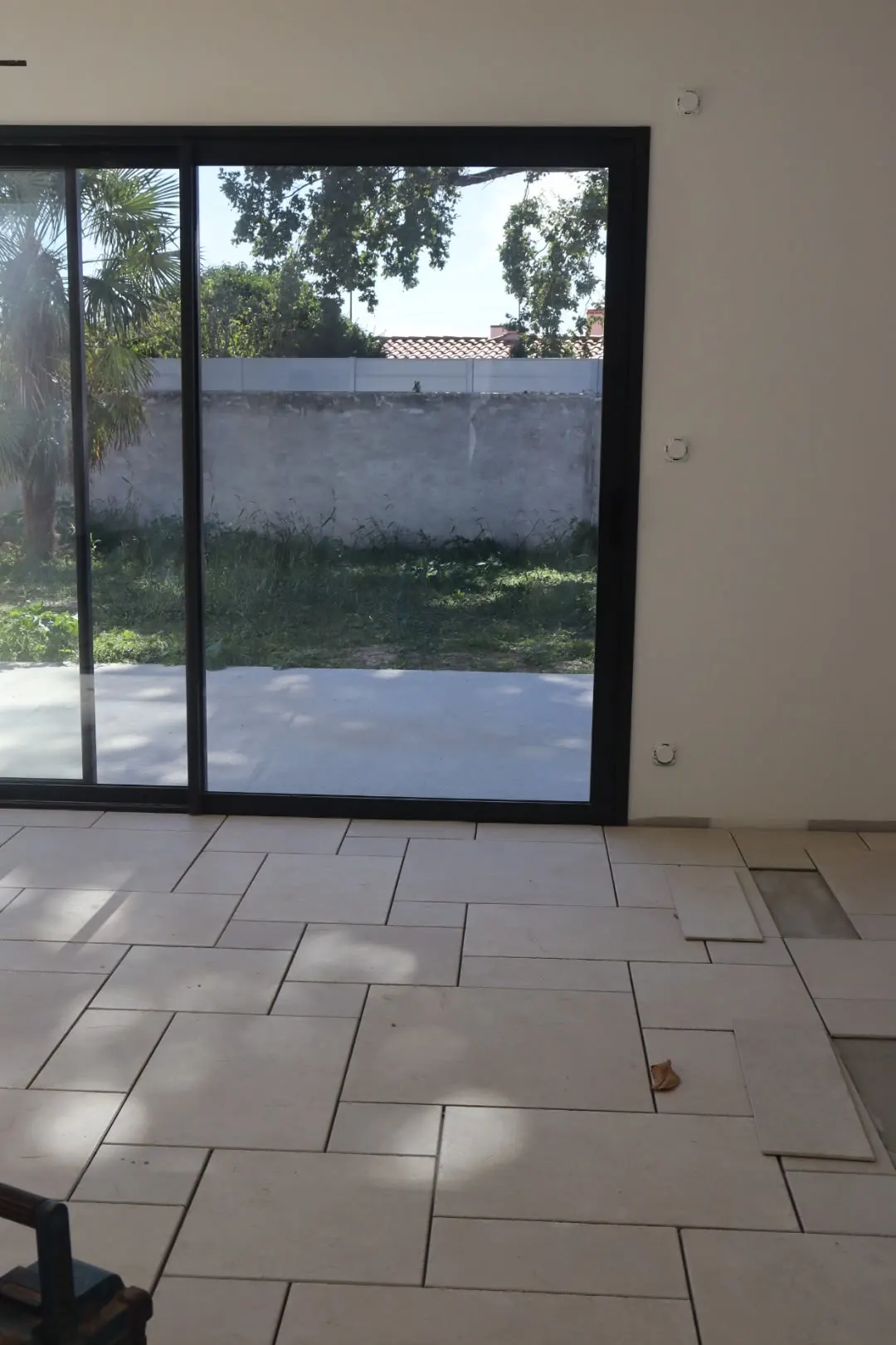 Séjour terminé, carrelage en opus devant une baie vitrée ouverte sur le jardin